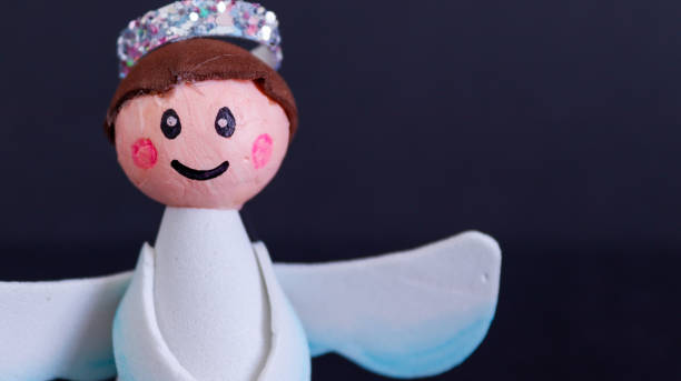 istock smiling christmas angel on black background, handmade 1350416062