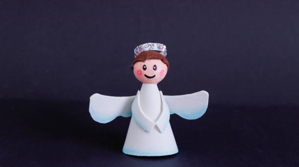 istock smiling christmas angel on black background, handmade 1350416063