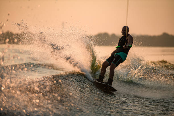 istock Great view of splashing wave and cheerful man energetically riding wakeboard. 1350418416