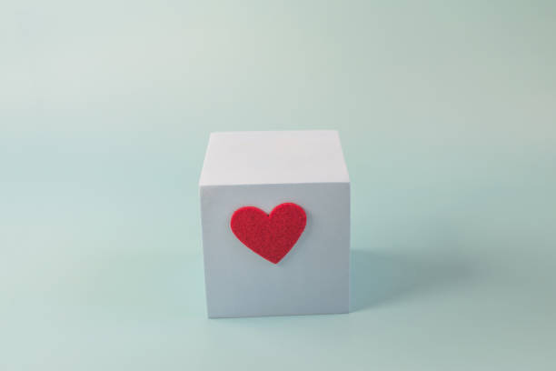 istock Abstract blue cube with a bright heart on a blue background. Podium in the form of a cube a place for text 1350418429
