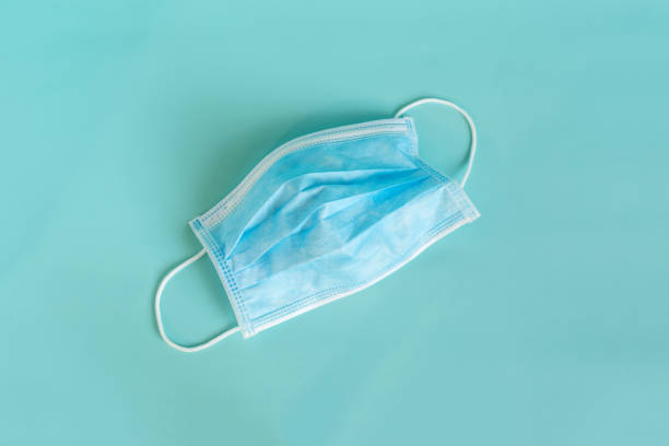 istock Ordinary medical mask close-up on a blue background 1350418446