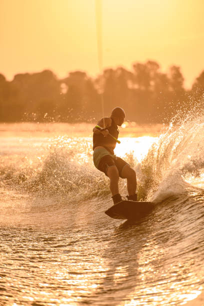 istock man holds rope and speedly riding wakeboard on the river. 1350418486