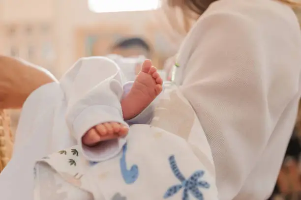 little baby feet baby on mother's arm