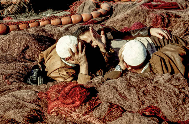 Casablanca, Morocco - May 5, 1984: men lying on fishing nets and discuss. Fishing is still an important industry for Morocco.