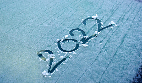 2022 is written on the windshield of the car, in the snow. New Year. Winter.