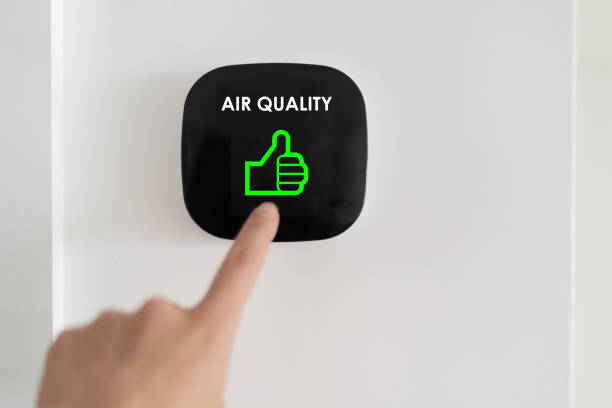 Good air quality indoor smart home domotic touchscreen system. air. Woman touching touchscreen checking air purifier filter at green level with thumbs up graphics