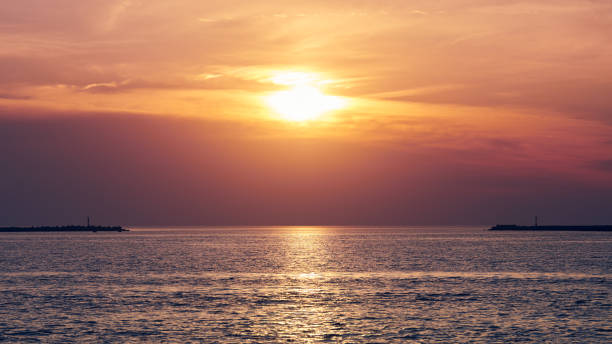 istock Calm sea with sunset sky, beautiful panoramic view, amazing dramatic rising sun reflected in water 1350428718
