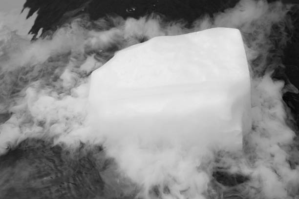 Dry ice evaporates in the water. Steam from a large piece of ice. Chemical experiment. Dry ice evaporates in the water. Steam from a large piece of ice. Chemical experiment. Distribution of fog over water. glass cup of boiling water stock pictures, royalty-free photos & images