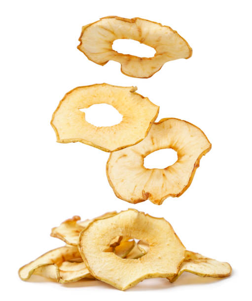 apple chips are falling on a heap on a white background. isolated - dried apple imagens e fotografias de stock