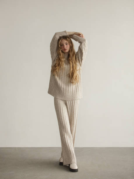 jeune belle femme portant un pull et un pantalon tricotés - mode bcbg photos et images de collection