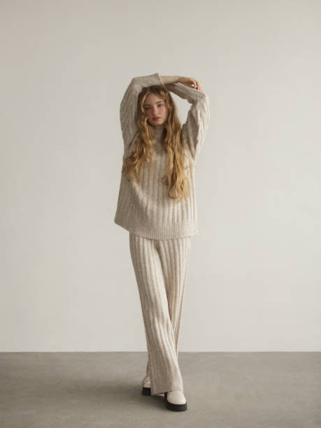 Young beautiful woman wearing knitted sweater and pants Portrait of young beautiful woman wearing beige knitted sweater and pants winter fashion stock pictures, royalty-free photos & images
