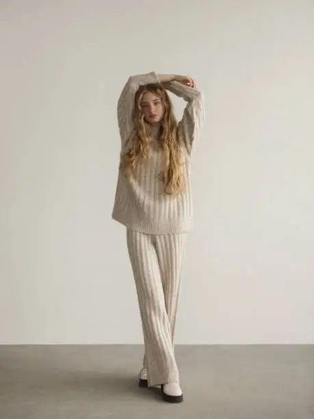 Portrait of young beautiful woman wearing beige knitted sweater and pants