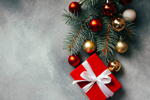 istock Christmas background with copy space. Christmas tree branches, red gift box and Christmas decorations. Top view. 1350431878