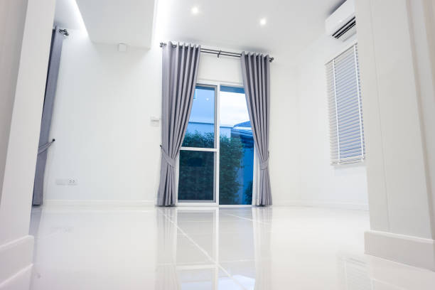 White empty space or room consist of ceramic tile floor in perspective view, white wall, ceiling, venetian blind, curtain, ceiling strip light. That is modern luxury interior home design of living room, bathroom, toilet, kitchen or laundry room look clean, bright, shiny surface of white ceramic tile floor texture or pattern for background.