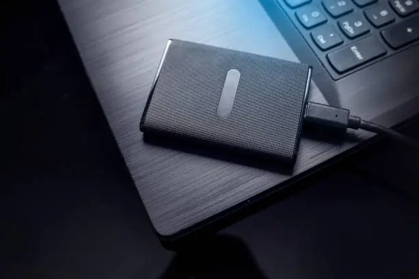 Data storage, protection of personal information concept. SSD disk inserted into the notebook.