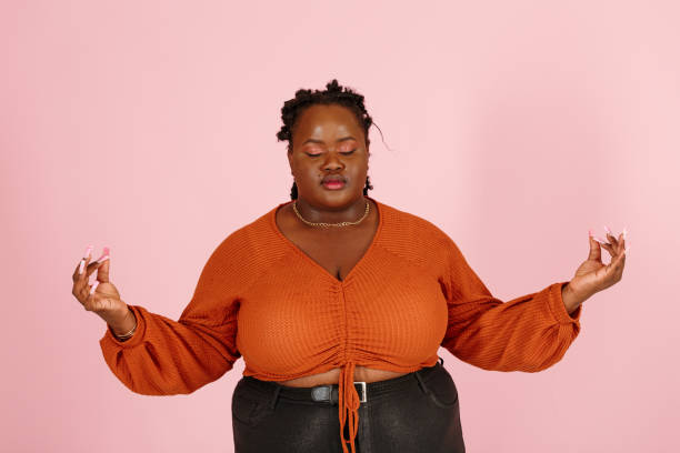 istock Tranquil black woman meditates standing on pink background close view 1350433431