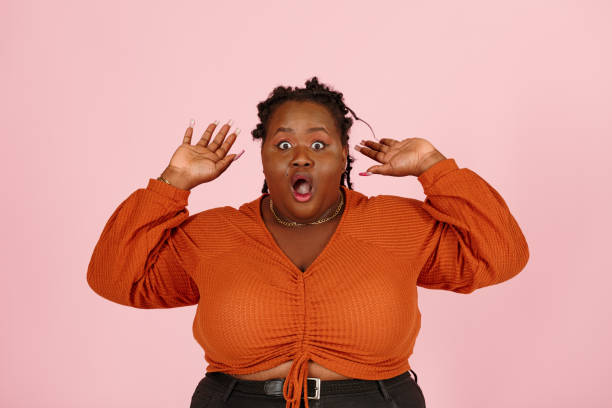 istock Amazed black woman throws up hands on pink background 1350433641