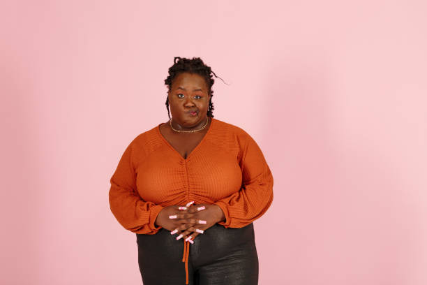 istock Skeptical black woman looks at camera on pink background 1350434425