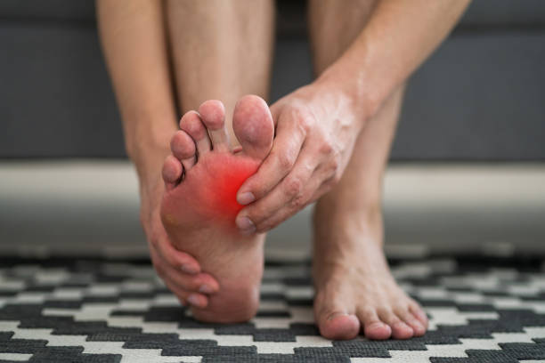 dolore ai piedi, uomo che soffre di mal ai piedi a casa - reflexology human foot physical therapy massaging foto e immagini stock