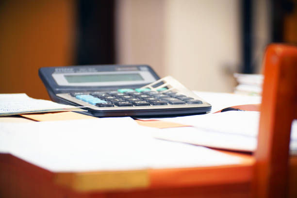 istock An old calculator on the table with documents and business papers 1350435268