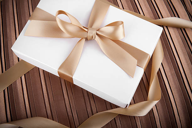 istock holiday scene white gift box with golden ribbon 135044293