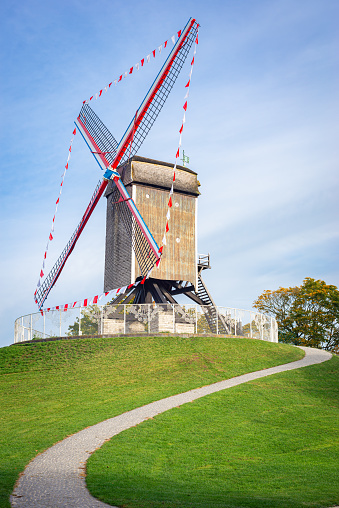 Brugge, Belgium - October 2021: Classic windmill on rampart Kruisvest in the historic town of Brugge, Belgium. Name of the windmill is Sint-Janshuismolen.