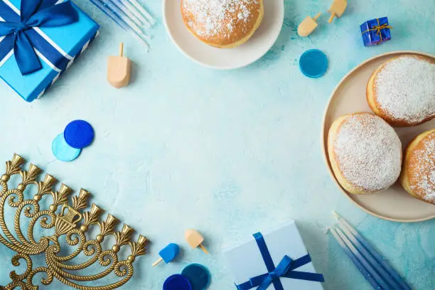 Frame border design for jewish holiday Hanukkah with traditional donuts, menorah and gift box. Top view, flat lay