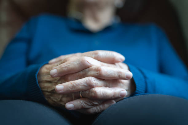 Older woman's hands with crossed fingers in resting and relaxed attitude.