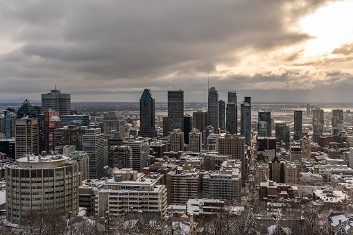 Montreal city skyline during a cloudy and snowy sunrise of winter seen from the Mount Royal.