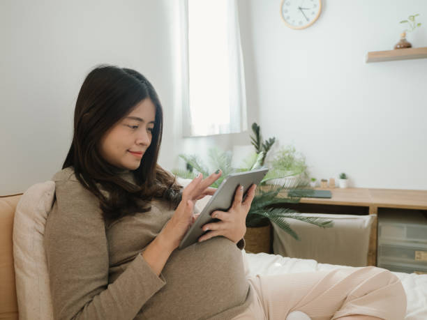 istock Young pregnant watching ultrasound image on digital tablet. 1350456270