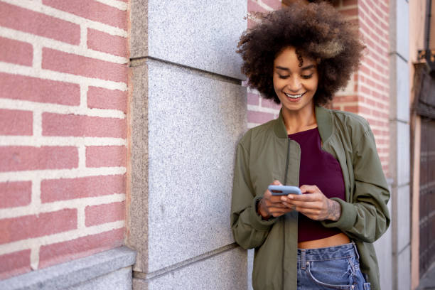 istock Happy young mixed race woman using a smart phone to call for an Uber 1350457893