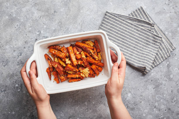 batata doce com queijo apoiado em tigela em fundo cinza - sweet potato french fries yam baked - fotografias e filmes do acervo