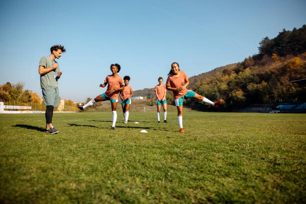 istock Girls soccer team talking to coach on training 1350458755