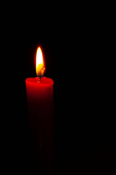istock A red candle with a flame on a black background. Copy space. vertical snapshot. The concept of memory, sorrow, hope, rip., tragedy, emergency. 1350458869