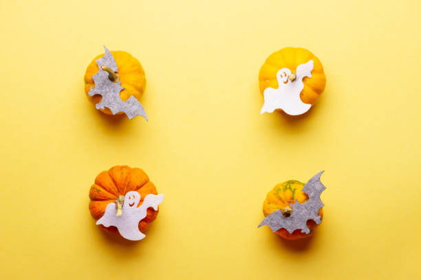 istock Ghosts on pumpkins on a yellow background 1350459164