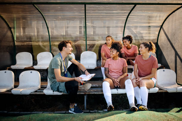 trenerka piłki nożnej wyjaśniająca strategie meczowe swojej kobiecej drużynie piłkarskiej - soccer bench soccer player sport zdjęcia i obrazy z banku zdjęć