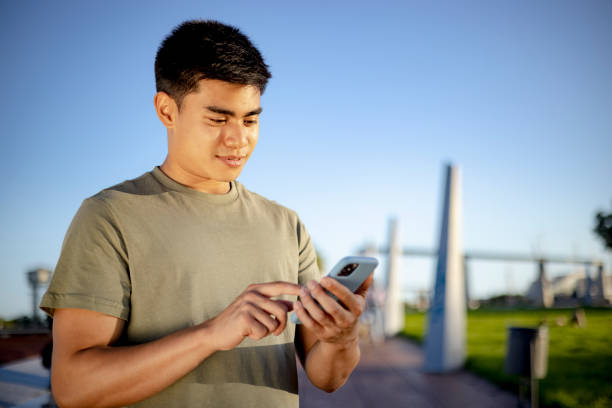 istock Happy young mixed race man using a smart phone outdoors 1350463611