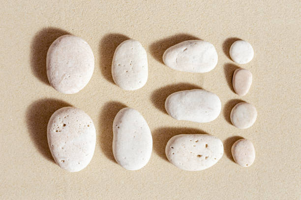 istock Aesthetic minimal pattern with set of pebble stones on fine sand background. Square composition from natural stone neutral beige color 1350464888