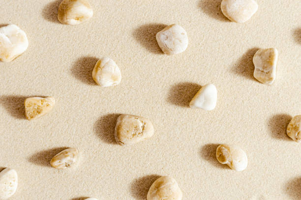 istock Pattern with close up pebble sea stones on sand texture. Layout from natural stone neutral natural tones. Minimal style sandy background 1350464904