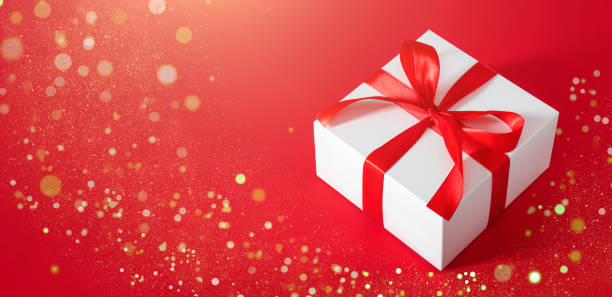 istock gift box on red background with red bow with place for text 1350465414