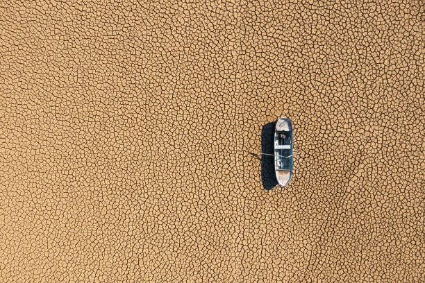 aerial view of a fishing boat on a drought dry lakebed. - lakebed imagens e fotografias de stock