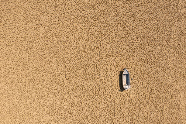 aerial view of a fishing boat on a drought dry lakebed. - lakebed imagens e fotografias de stock