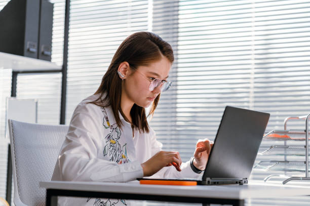 istock Businesswoman Analyzing Statistical Business Reports on her Laptop PC at the Office. 1350470570
