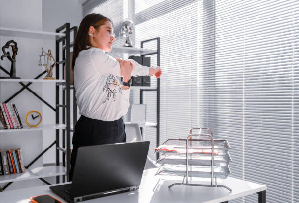 istock Woman stretching while working from a home office 1350471813
