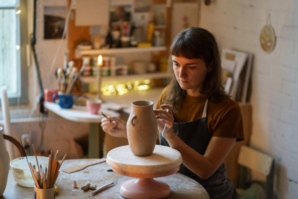 istock Young girl art classes student or ceramics studio owner create vase for master class in workshop 1350472988