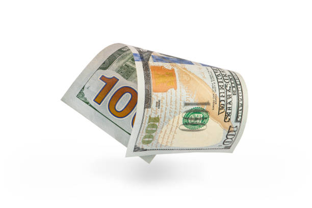 istock Hundred dollar bill falling casting shadow, half-folded bill close-up on white background 1350473324