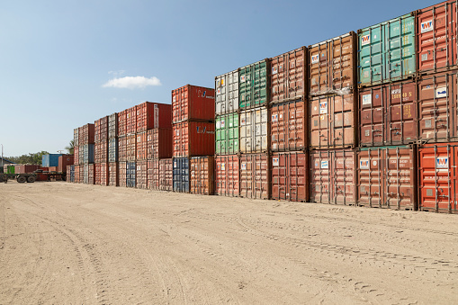 Labuan Bajo, Indonesia - Aug 25, 2019: Rows of dry van type containers piled up in the sun in the dusty Labuan Bajo port area