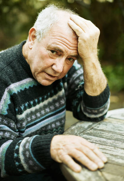 istock Senior man clutches his head and looks desperate 1350479978