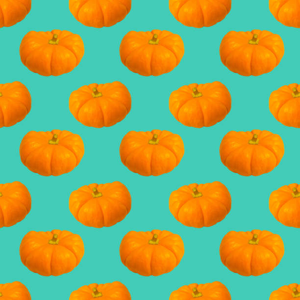 istock Ripe pumpkins on a turquoise background. Seamless pattern for textiles, clothing or paper packaging with a print 1350481870