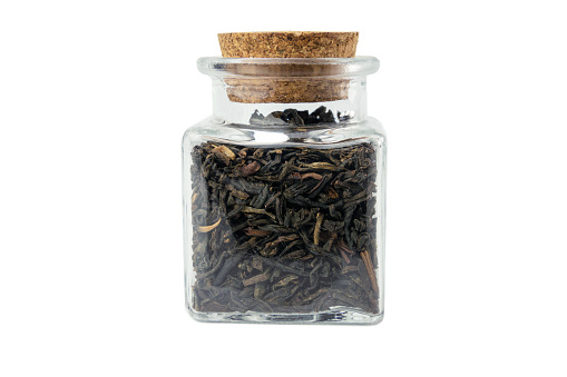 yunnan black tea in a glass jar isolated on white background.